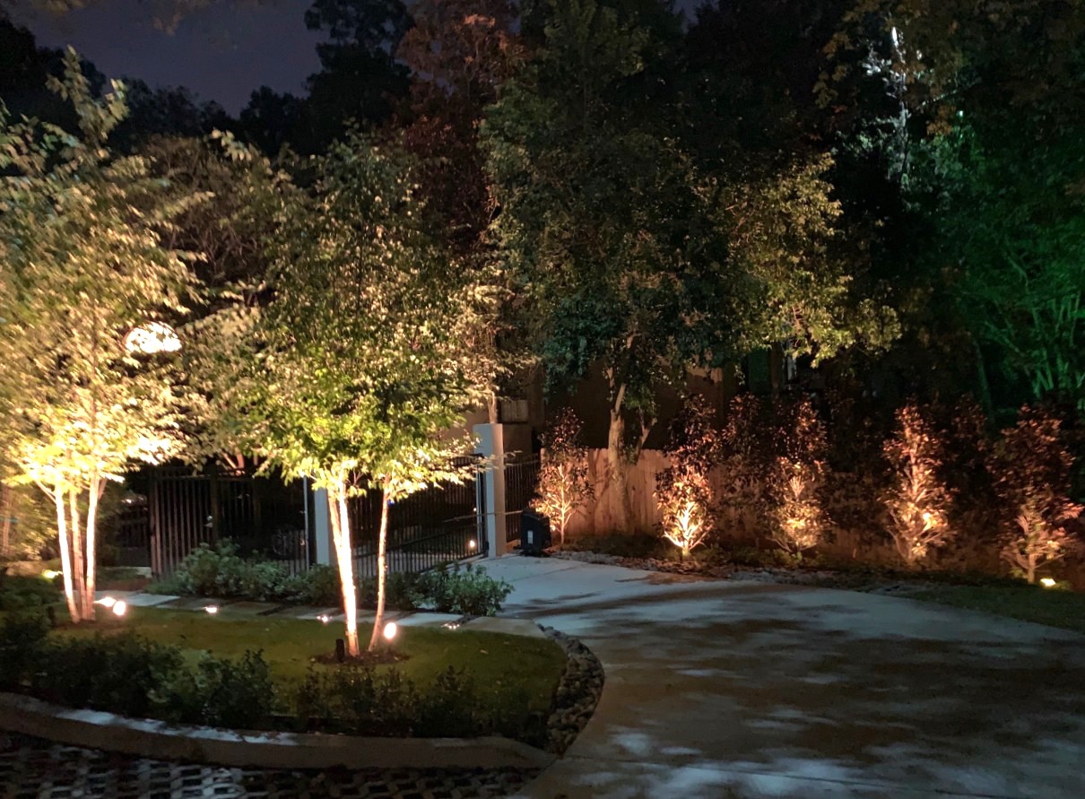 Home perimeter landscape lighting at driveway gate for safety.
